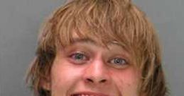 Mugshot of a young man smiling, showcasing a carefree attitude, often associated with the High Redneck culture.