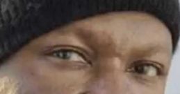 Close-up of an irate Black man wearing a black beanie, displaying a serious expression and intense gaze.