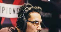 Focused male gamer wearing headphones, engaged deeply in competitive gaming at a championship event.