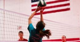 Player jumping to set a volleyball during practice, showcasing teamwork and skill in a vibrant indoor gym.