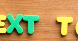 Colorful letters spelling "Text To Speech" on a wooden surface, representing technology for converting text into spoken words.