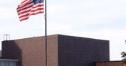 Modern school building with an American flag, featuring a welcoming entrance and landscaped surroundings.