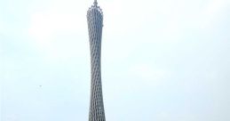 Guangzhou Tower rises majestically above lush greenery and a winding pathway, showcasing modern architectural design.