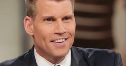 Scott Hanson smiles confidently in a tailored suit, showcasing a stylish tie and pocket square during a presentation.