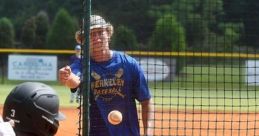 Berkeley Baseball player swings as a coach prepares to pitch during a practice session, focusing on hitting techniques.