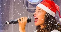 Singer in a festive Santa hat performs joyfully on stage during the Borrelshow, with snowflakes falling around her.