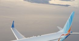 Flydubai Boeing 737 MAX soaring above the ocean with a scenic view of islands in the background and a clear sky.