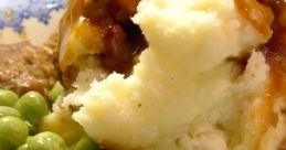 Delicious plate of meatloaf with gravy, creamy mashed potatoes, and vibrant green peas, perfect for a nostalgic meal.