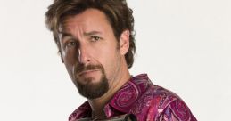 Character from Zohan holding a hairdryer, dressed in a vibrant paisley shirt, showcasing a comedic expression.