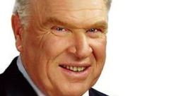 John Madden smiling in a suit, presenting with a football, embodying his legacy in football commentary and coaching.