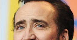 Nicolas Cage smiles during a press conference, showcasing his signature charm and distinctive beard style.