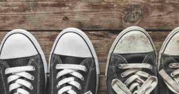 New black sneakers alongside worn-out shoes on a rustic wooden surface, showcasing the contrast between old and new footwear.