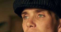 Close-up portrait of a character in Peaky Blinders, showcasing a sharp suit, iconic cap, and intense gaze.