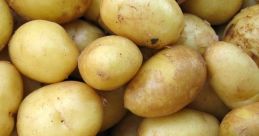 Fresh, golden potatoes stacked together, showcasing their smooth skin and earthy tones, perfect for various dishes.