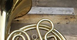 Elegant brass French horn with silver valves showcased on a rustic wooden surface, perfect for music lovers and musicians.