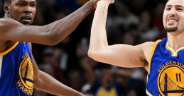 Kevin Durant and Klay Thompson celebrate a play during an NBA game, showcasing teamwork for the Golden State Warriors.