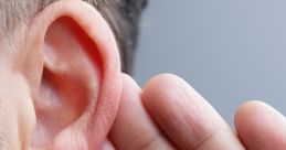 Close-up of a man's ear, with a hand cupping it, illustrating the act of listening intently for sound.