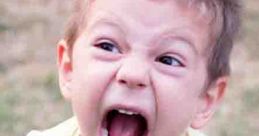 Young boy screaming with a shocked expression, depicting intensity and emotion in a vibrant outdoor setting.