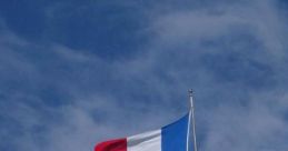 French flag flying against a blue sky, symbolizing national pride and identity in France.