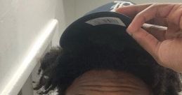 Casual selfie of a young man with dreadlocks adjusting his cap, embodying the vibrant energy of IShowSpeed's personality.