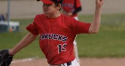 Young baseball pitcher in red jersey throws a fastball during a 15U AAA game, showcasing skill and athleticism.