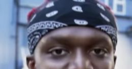 KSI in a casual outfit with a bandana, smiling against an urban backdrop, showcasing his vibrant personality.