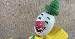 Vintage Fisher-Price clown toy car featuring a smiling clown with a red nose and colorful striped outfit. Perfect for collectors.