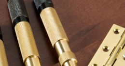 Gold and black punch tools on a wooden surface, showcasing precision detailing for crafting and woodworking projects.