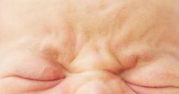 Crying baby with a distressed expression, showcasing emotion and vulnerability in a close-up shot.