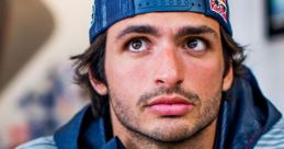 Carlos Sainz in Red Bull racing gear, looking intently, showcasing his passion for Formula 1 and motorsport excellence.