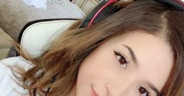 Pokimane wearing headphones, smiling at the camera, surrounded by a cozy gaming setup in her stylish room.