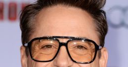 Robert Downey Jr. smiling in stylish glasses at a premiere event, showcasing his charismatic personality and fashion sense.