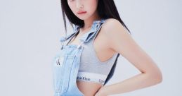 Jennie poses confidently in a stylish denim overall dress, showcasing her trendy fashion sense and iconic style.