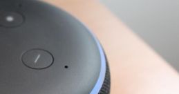 Close-up of an Alexa smart speaker featuring control buttons and glowing light ring, showcasing modern design and functionality.