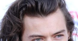 Close-up of Harry Styles with tousled hair and piercing blue eyes, showcasing his striking features and timeless style.