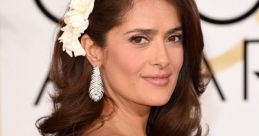 Salma Hayek at the Golden Globes, showcasing elegant style with a floral accent and stunning jewelry.