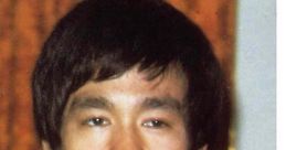 Bruce Lee with a confident expression, showcasing his iconic hairstyle and style, representing martial arts legacy.