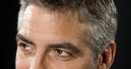 Close-up portrait of George Clooney, showcasing his distinguished gray beard and stylish suit against a dark background.