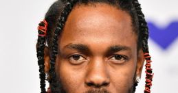 Kendrick Lamar showcasing distinct style with braided hair and layered necklaces at a public appearance.