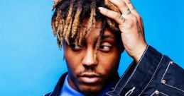 Juice WRLD poses thoughtfully against a vibrant blue background, showcasing his unique style and expressive personality.