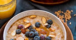 Delicious porridge topped with fresh blueberries, almonds, and a side of orange juice for a healthy breakfast.