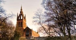 Historic bridge over the snow-covered River Kelvin with a majestic church spire in the background during winter.