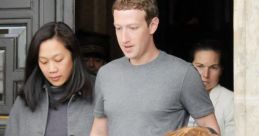 Mark Zuckerberg, casually dressed, exits a building alongside a woman, surrounded by others, in a candid moment.