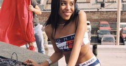 Aaliyah Haughton spinning records on turntables, showcasing her hip hop and R&B style in vibrant Tommy Hilfiger attire.