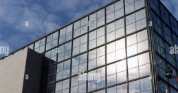 Modern architecture of a Croatian library featuring glass facade and steps against a cloudy blue sky.