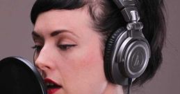 Australian female recording artist with headphones capturing voice for computer-generated audio production.