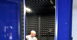 Man playing guitar in a portable vocal booth, showcasing optimal sound quality for recording in-house vocal libraries.