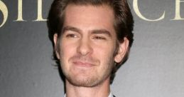 Andrew Garfield smiles confidently in a stylish suit at a film premiere, showcasing his charismatic on-screen presence.