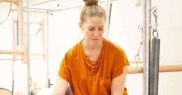 Pilates instructor assists a student with stretching techniques on a reformer, promoting flexibility and wellness.