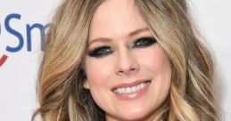 Avril Lavigne smiles confidently, showcasing her wavy hair and striking makeup at a recent event.